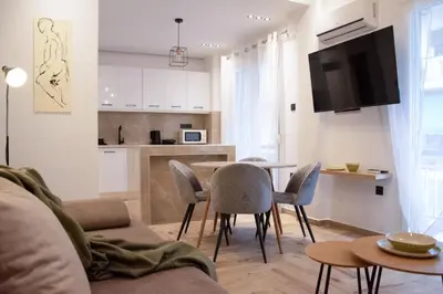 a living room with a couch and a table and chairs at Apartment in Athens Neos Kosmos in Athens