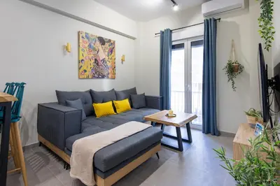 a living room with a blue couch and a table at Cesily 2-Bedroom Apartment in Athens in Athens