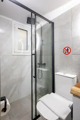 a bathroom with a toilet and a glass shower at Cesily 2-Bedroom Apartment in Athens in Athens