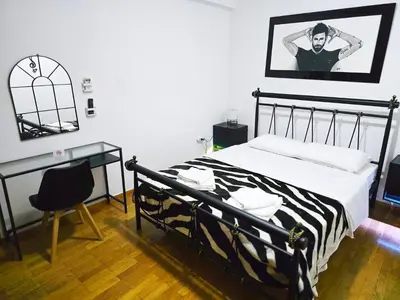 a bedroom with a black and white bed and a desk at Nicko’s room in Piraeus