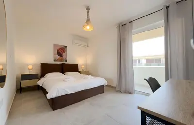 a bedroom with a bed and a large window at Kanari Sea View 55sqm apt in Alimos in Athens
