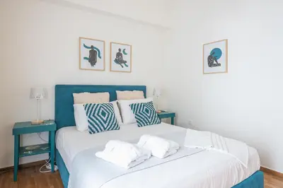 a bedroom with a blue and white bed with pillows at Quiet Embassy Suite by CloudKeys in Athens