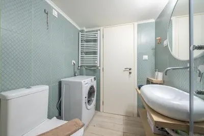 a bathroom with a toilet and a sink and a washing machine at Quiet Embassy Suite by CloudKeys in Athens