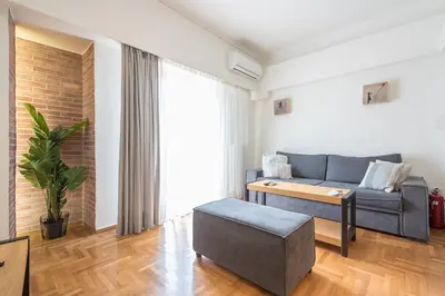 a living room with a couch and a table at Quiet Embassy Suite by CloudKeys in Athens