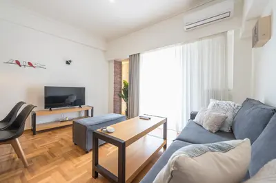 a living room with a blue couch and a table at Quiet Embassy Suite by CloudKeys in Athens
