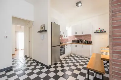 a kitchen with a refrigerator and a checkered floor at Quiet Embassy Suite by CloudKeys in Athens