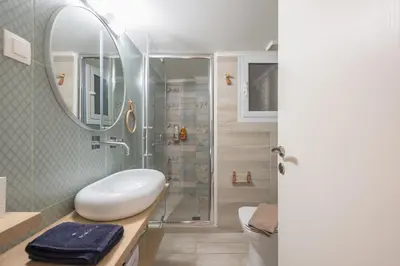 a bathroom with a shower and a toilet and a sink at Quiet Embassy Suite by CloudKeys in Athens