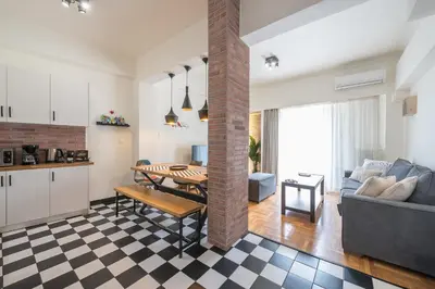 a kitchen and living room with a table and a couch at Quiet Embassy Suite by CloudKeys in Athens