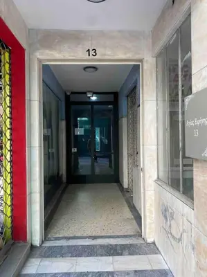 a hallway leading to a building with a sign on it at STM Monastiraki Acropolis Apt in Athens
