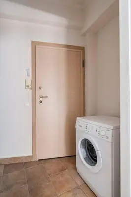 a white washing machine in a room with a door at STM Monastiraki Acropolis Apt in Athens