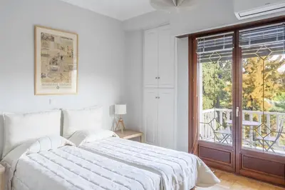a white bedroom with a large bed and a window at Amazing location - 2 min from Acropolis in Athens