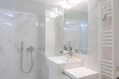 a white bathroom with a sink and a shower at Amazing location - 2 min from Acropolis in Athens