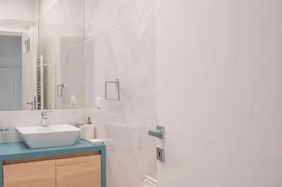 a white bathroom with a sink and a mirror at Amazing location - 2 min from Acropolis in Athens