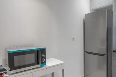 a microwave sitting on a counter next to a refrigerator at Amazing location - 2 min from Acropolis in Athens