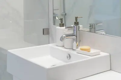 a white bathroom with a sink and a mirror at Amazing location - 2 min from Acropolis in Athens