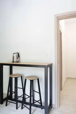a table with two stools in a room at New and renovated studio close to Megaro Mousikis in Athens