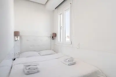 two beds in a white room with a window at Penthouse with views close to Monastiraki metro in Athens
