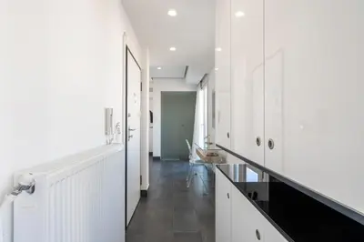 a hallway with white cabinets and a long hallway at Penthouse with views close to Monastiraki metro in Athens