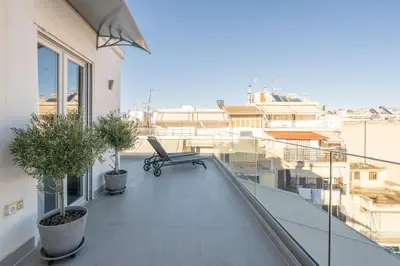 a balcony with a bench and a view of a city at Penthouse with views close to Monastiraki metro in Athens