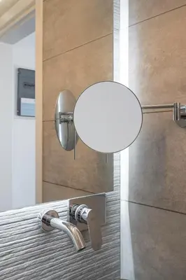 a bathroom with a sink with a light on the wall at Penthouse with views close to Monastiraki metro in Athens