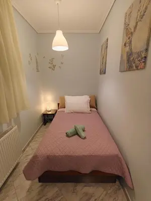 a bedroom with a bed with two green towels on it at Rsquared (Riviera Residence) in Aghia Marina