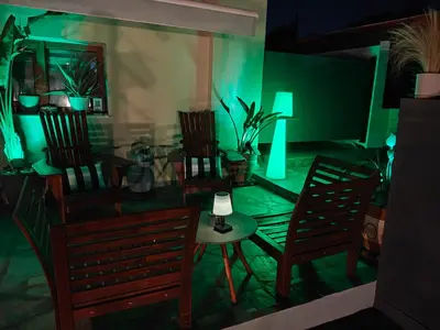 a room with chairs and a table with green lights at Rsquared (Riviera Residence) in Aghia Marina
