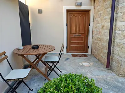 a patio with a table and chairs and a door at Rsquared (Riviera Residence) in Aghia Marina