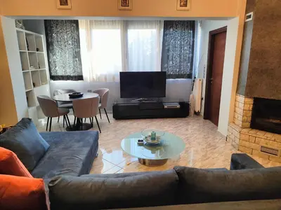 a living room with a couch and a table and a television at Rsquared (Riviera Residence) in Aghia Marina