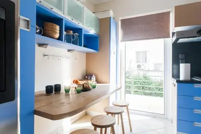 a kitchen with blue cabinets and stools in it at Elegant Maisonette 4BD Glyfada in Athens