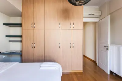 a bedroom with wooden cabinets and a bed at Elegant Maisonette 4BD Glyfada in Athens