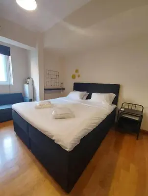 a bedroom with a large bed with white sheets at Elegant Maisonette 4BD Glyfada in Athens