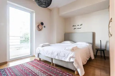 a bedroom with a bed and a large window at Elegant Maisonette 4BD Glyfada in Athens