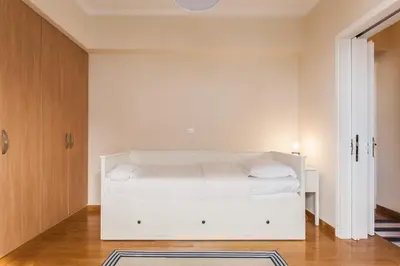 a white bedroom with a white bed in it at Elegant Maisonette 4BD Glyfada in Athens