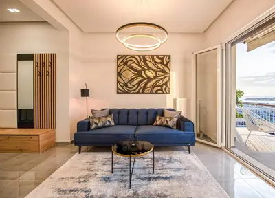 a living room with a blue couch and a table at Two Bedroom Sea View Apartment in Glyfada Beach in Athens