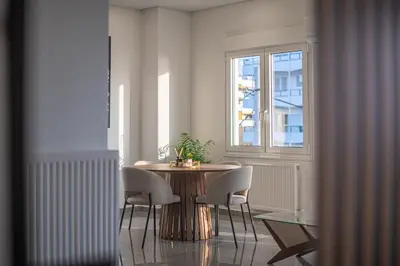 a dining room with a table and chairs and a window at Two Bedroom Sea View Apartment in Glyfada Beach in Athens
