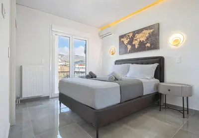 a bedroom with a large bed and a large window at Two Bedroom Sea View Apartment in Glyfada Beach in Athens