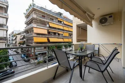 a balcony with a table and chairs and a building at Chic and Lavish Apartment in Athens in Athens