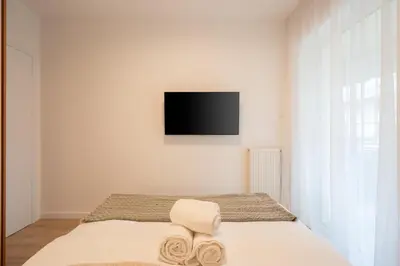 a bedroom with a bed with a tv on the wall at Chic and Lavish Apartment in Athens in Athens