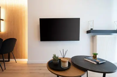 a living room with a table and a tv on a wall at Chic and Lavish Apartment in Athens in Athens