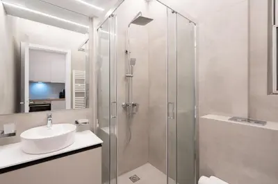 a bathroom with a sink and a glass shower at Chic and Lavish Apartment in Athens in Athens