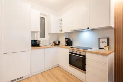a kitchen with white cabinets and a stove at Chic and Lavish Apartment in Athens in Athens