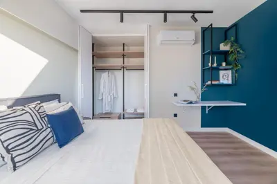 a bedroom with a large bed and a blue accent wall at Exceptional Living Lofts by UPSTREET in Athens