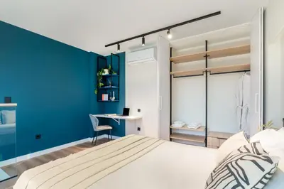 a bedroom with blue walls and a bed with a desk at Exceptional Living Lofts by UPSTREET in Athens