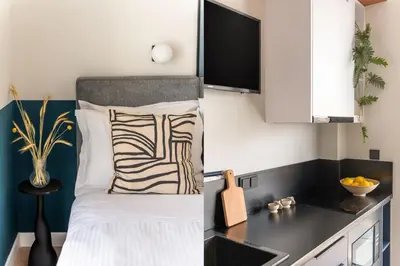a bedroom with a bed with a monitor on the wall at Exceptional Living Lofts by UPSTREET in Athens