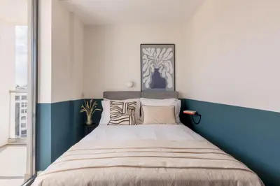 a bedroom with a large bed with blue and white walls at Exceptional Living Lofts by UPSTREET in Athens