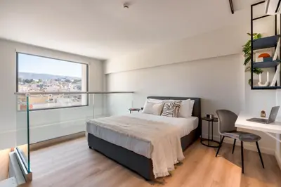 a bedroom with a bed and a desk and a window at Exceptional Living Lofts by UPSTREET in Athens