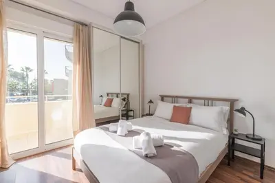 a bedroom with a large bed and a large window at The HostMaster Beachside Retreat in Vari