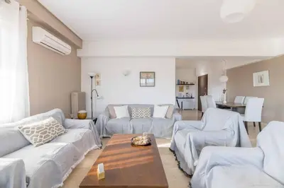a living room with white couches and a table at The HostMaster Beachside Retreat in Vari