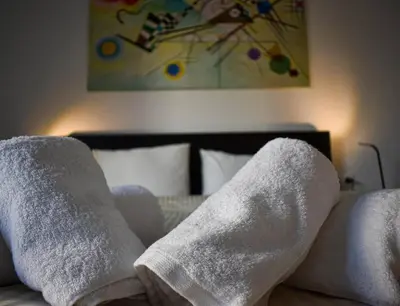a bed with white towels on it with a painting at Glyfada Maisonette by Taurus in Athens