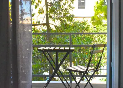 a table and a chair sitting on a balcony at Glyfada Maisonette by Taurus in Athens